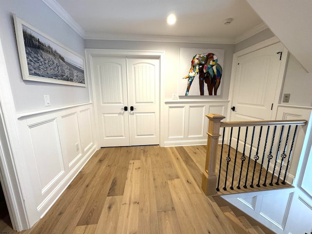 corridor featuring light hardwood / wood-style floors and crown molding