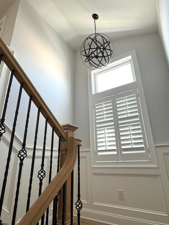 stairs featuring a notable chandelier