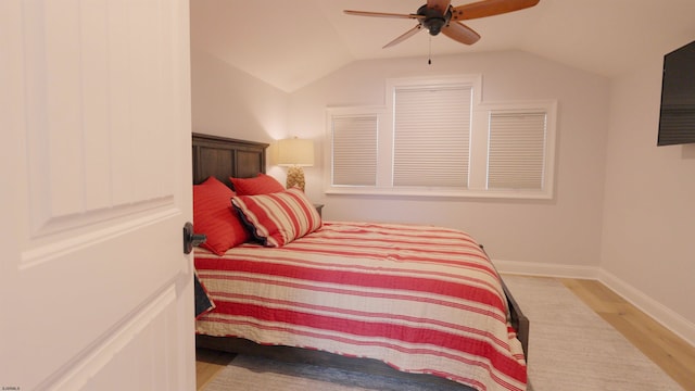 bedroom with ceiling fan, vaulted ceiling, and light hardwood / wood-style flooring