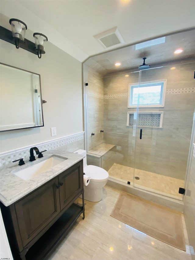 bathroom featuring tile patterned flooring, toilet, a shower with shower door, ceiling fan, and vanity