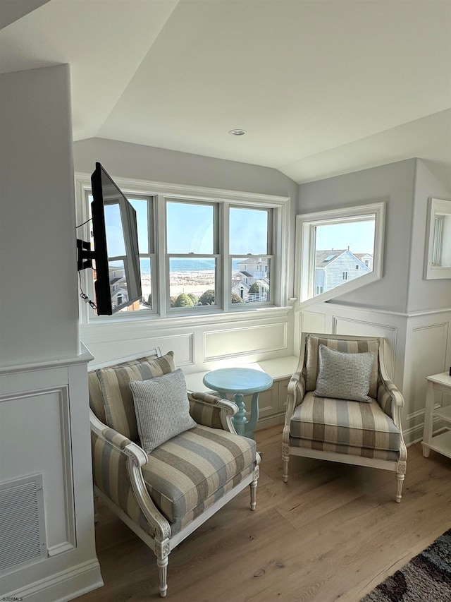 sitting room featuring lofted ceiling, a wealth of natural light, and light hardwood / wood-style floors