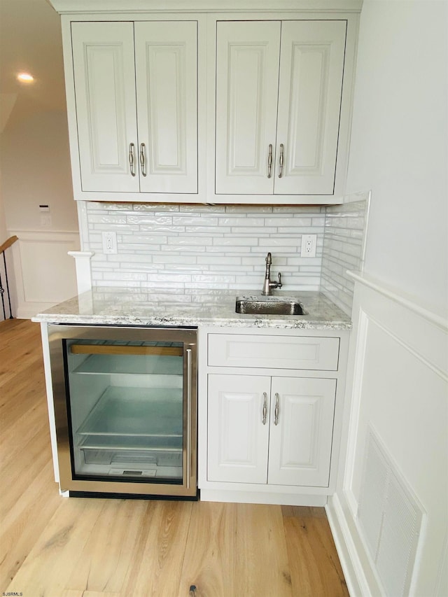 bar with white cabinets, wine cooler, and sink