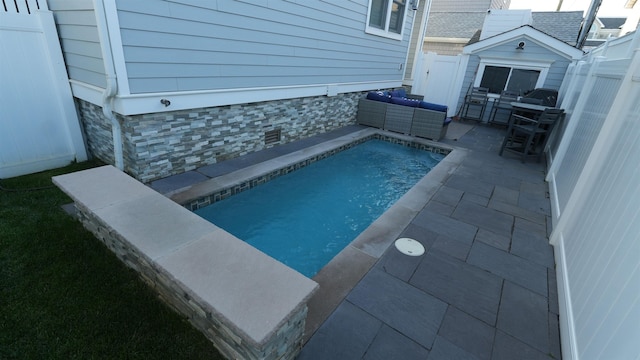 view of swimming pool featuring a storage unit and a patio area