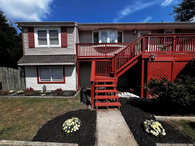 view of front of house with a front yard and a wooden deck