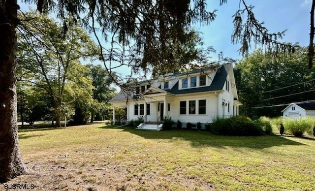 view of front of property with a storage shed and a front yard