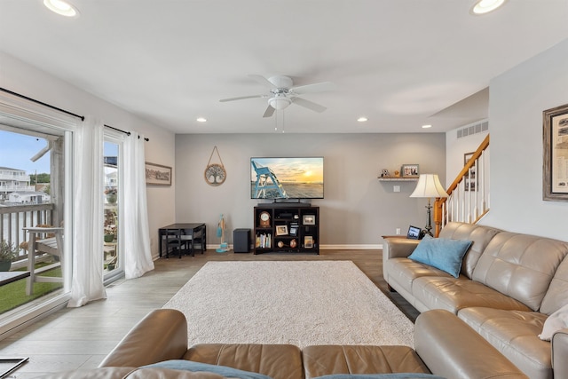 living room with light hardwood / wood-style flooring, ceiling fan, and plenty of natural light