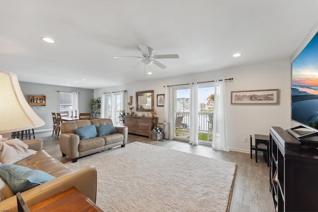 living room featuring light hardwood / wood-style floors and ceiling fan