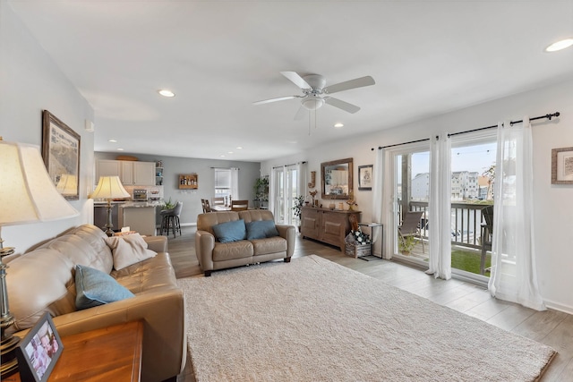 living room featuring light wood-type flooring and ceiling fan