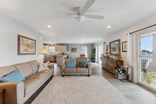 living room with light hardwood / wood-style flooring and ceiling fan