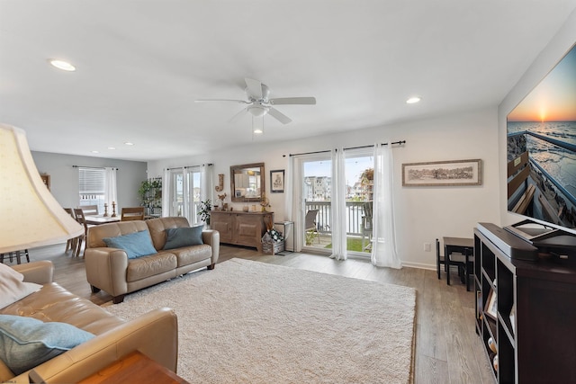 living room featuring light hardwood / wood-style flooring and ceiling fan