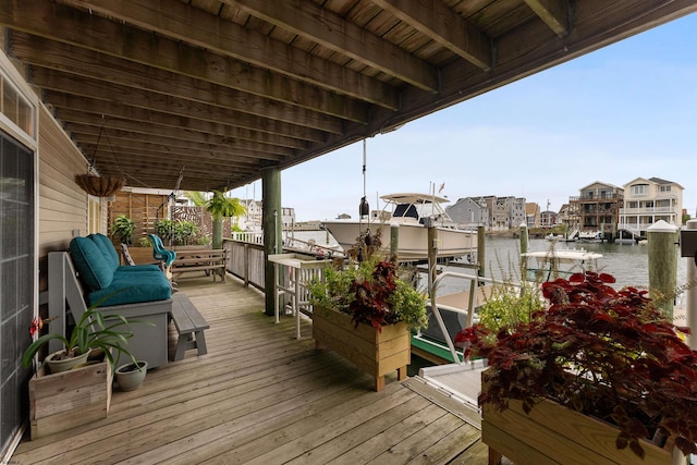 wooden deck featuring a boat dock and a water view