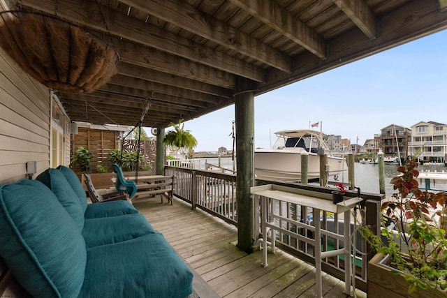 wooden deck featuring a boat dock, a water view, and an outdoor living space