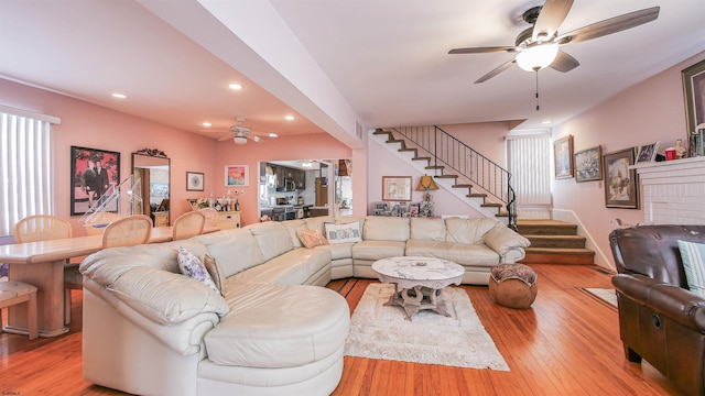 living room with ceiling fan and light hardwood / wood-style flooring