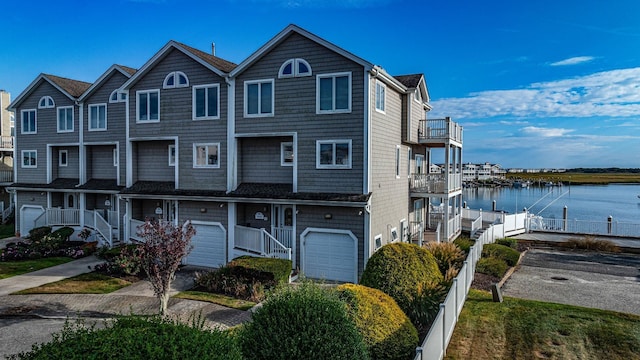 view of front of property with a balcony, a garage, and a water view