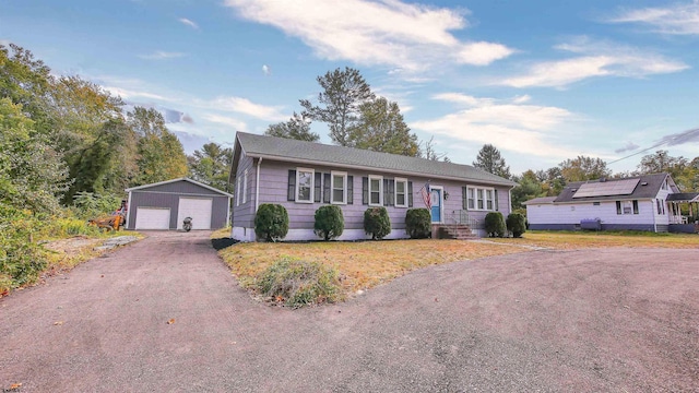 single story home featuring a garage and an outbuilding