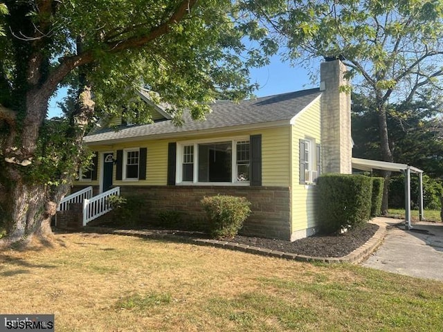 view of front of house with a front yard and a carport