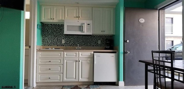 kitchen with light tile patterned floors, white cabinetry, decorative backsplash, electric cooktop, and dishwashing machine