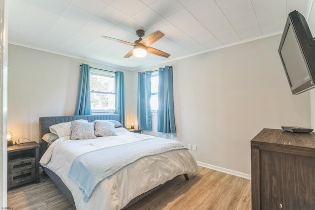 bedroom with ceiling fan, light hardwood / wood-style flooring, and crown molding