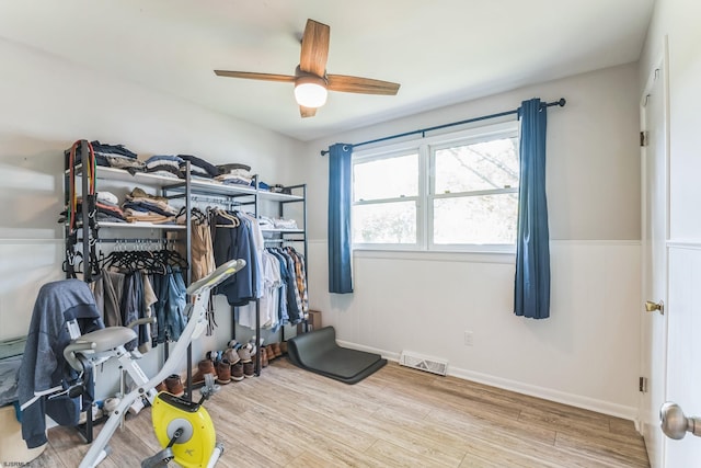 workout area featuring ceiling fan and light hardwood / wood-style floors