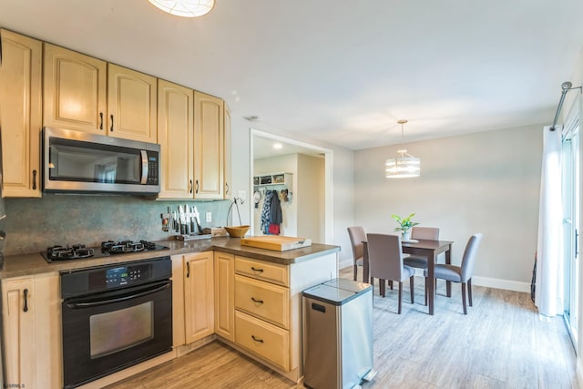 kitchen featuring tasteful backsplash, black oven, gas stovetop, light hardwood / wood-style flooring, and decorative light fixtures