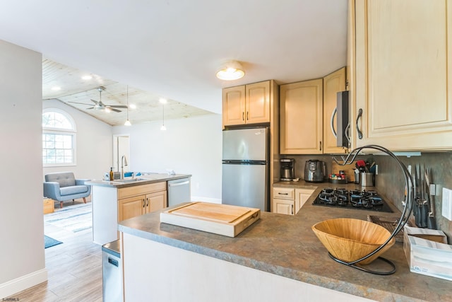 kitchen with light wood-type flooring, sink, kitchen peninsula, appliances with stainless steel finishes, and ceiling fan