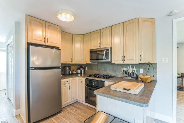 kitchen with black appliances, light hardwood / wood-style floors, light brown cabinets, and tasteful backsplash