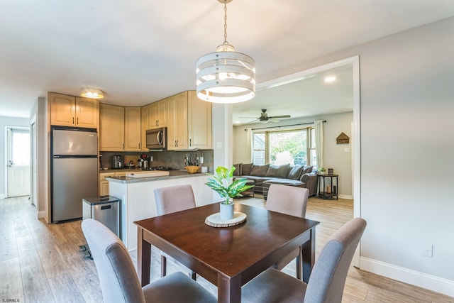 dining area with ceiling fan with notable chandelier and light wood-type flooring