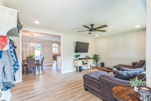 living room featuring light wood-type flooring and ceiling fan