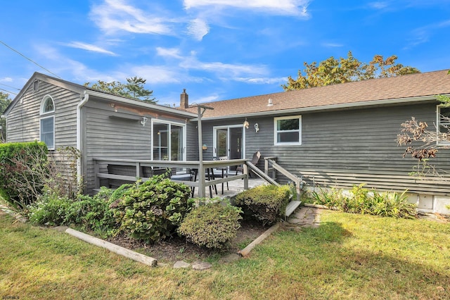 rear view of house with a lawn and a deck