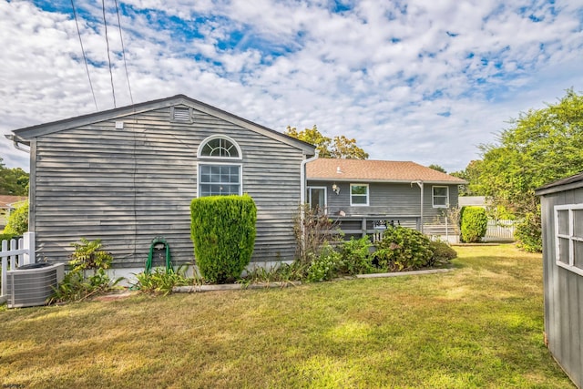 back of house with a lawn and cooling unit