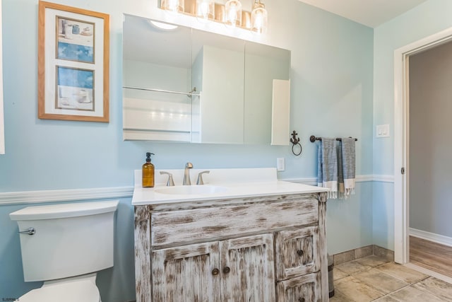 bathroom featuring tile patterned flooring, vanity, and toilet