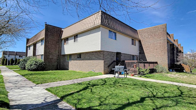 view of side of home with a lawn and a wooden deck