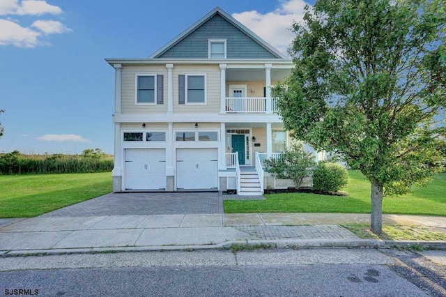 view of front of house featuring a garage, covered porch, and a front yard