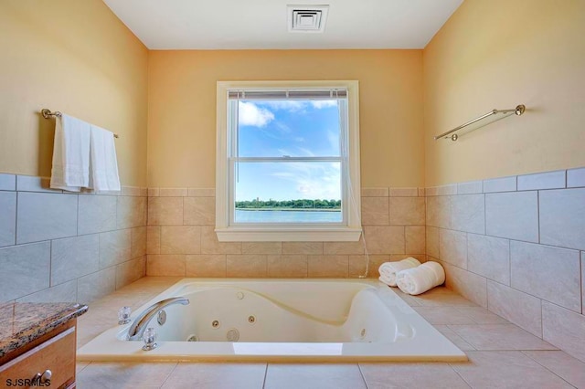 bathroom with tiled tub and vanity