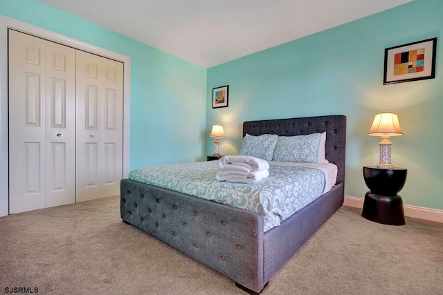 bedroom featuring light carpet and a closet