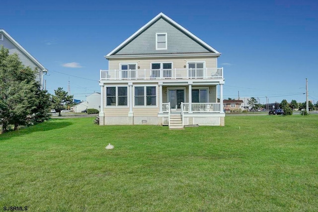 rear view of house featuring a balcony and a lawn