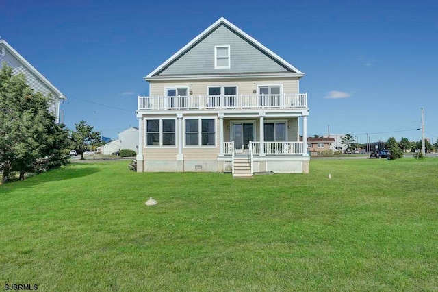 rear view of house with a lawn and a balcony