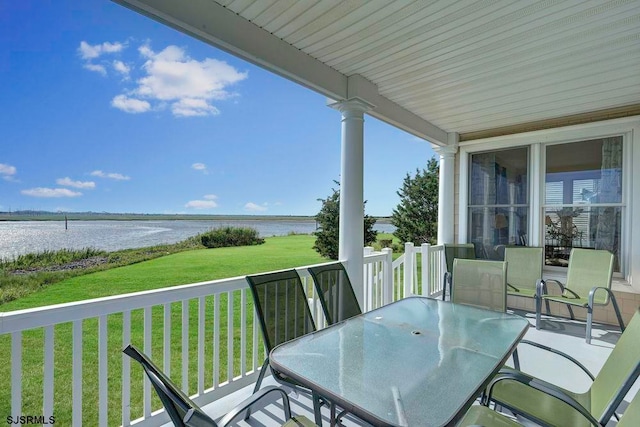 wooden terrace with a lawn and a water view