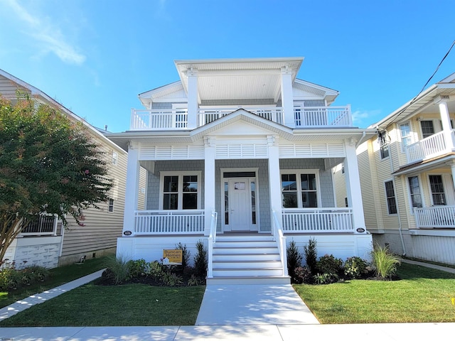 view of front facade with a balcony, covered porch, and a front yard