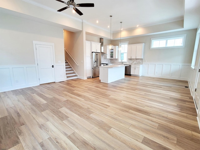 kitchen featuring a center island, white cabinets, hanging light fixtures, appliances with stainless steel finishes, and tasteful backsplash