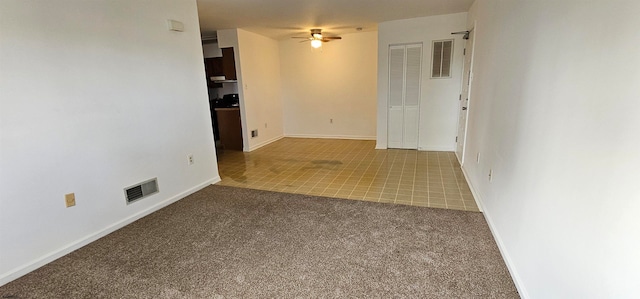 spare room with ceiling fan and light carpet