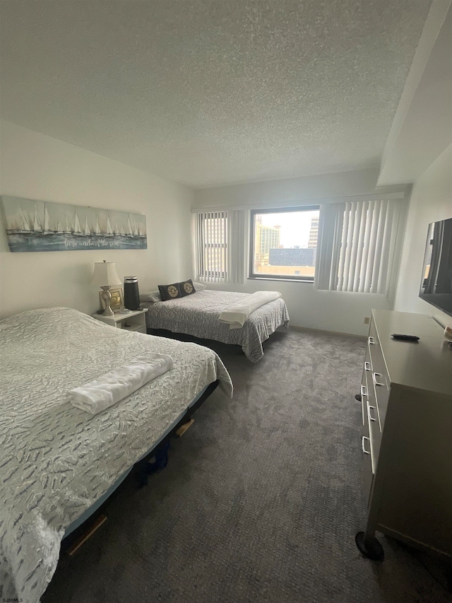 bedroom with dark carpet and a textured ceiling