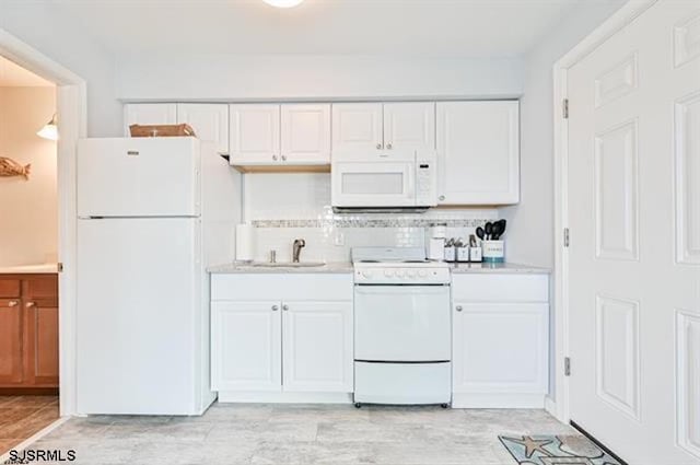 kitchen with decorative backsplash, sink, white appliances, and white cabinetry