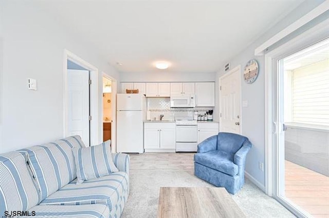 living room featuring sink and light colored carpet