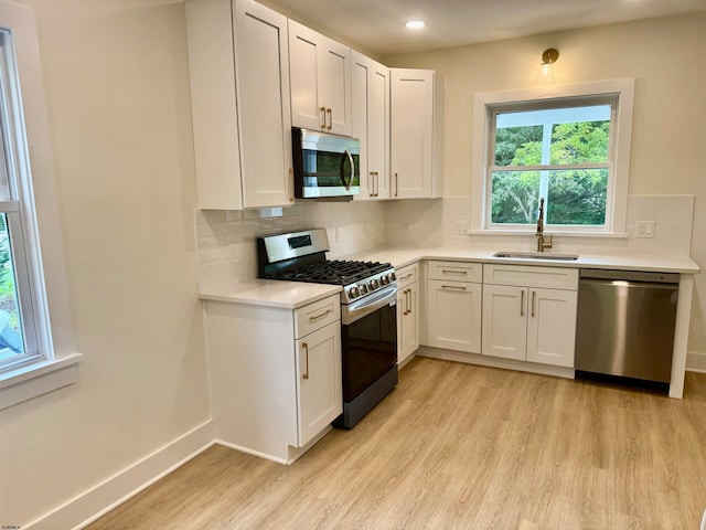 kitchen featuring light wood-type flooring, white cabinetry, sink, and stainless steel appliances