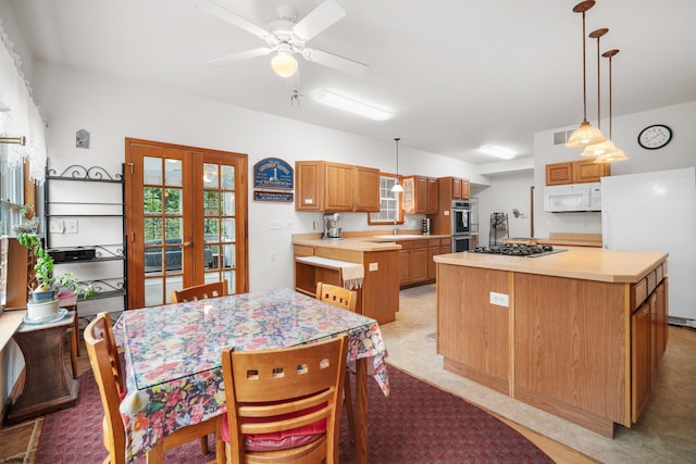 kitchen featuring pendant lighting, a center island, appliances with stainless steel finishes, ceiling fan, and french doors