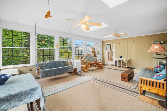 sunroom / solarium with ceiling fan and a skylight