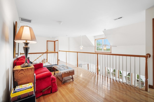 sitting room with ceiling fan and hardwood / wood-style flooring