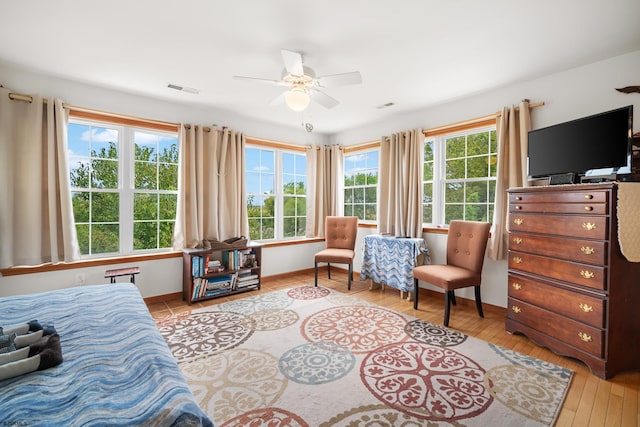 bedroom featuring light hardwood / wood-style flooring, multiple windows, and ceiling fan