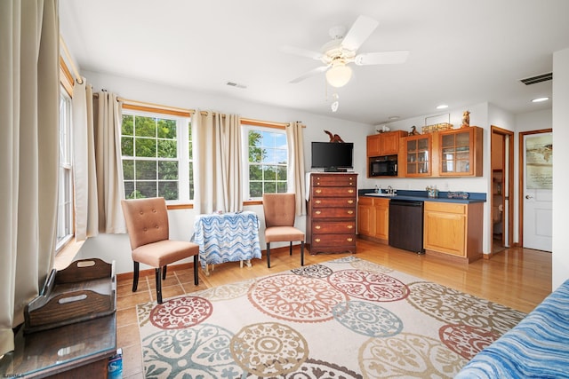 living room with light hardwood / wood-style floors, ceiling fan, and sink